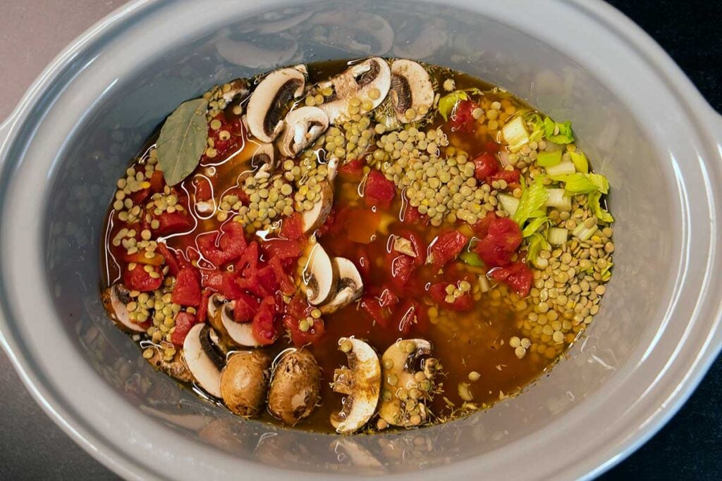 Lentil soup ingredients in a slow cooker.