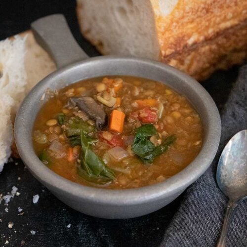 Slow cooker lentil soup with a loaf of bread.