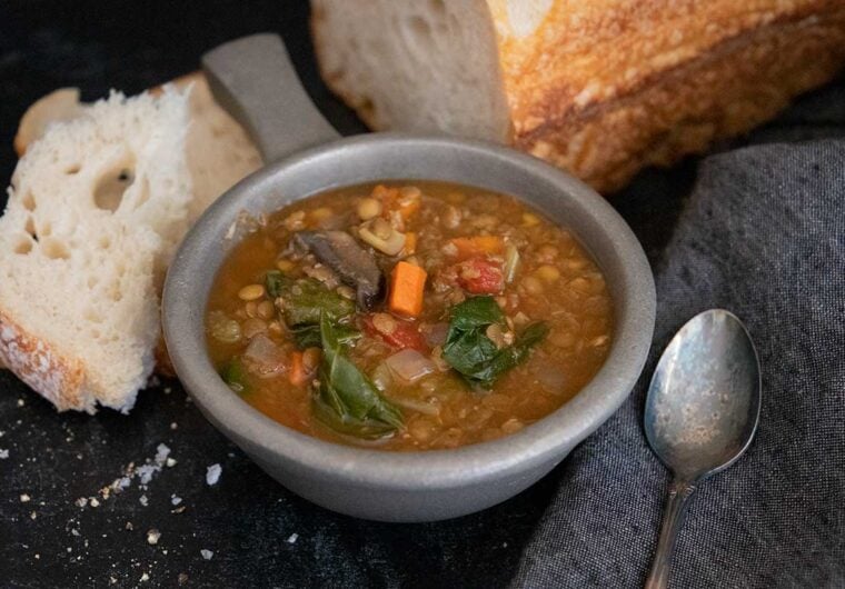 slow cooker lentil soup with a loaf of bread