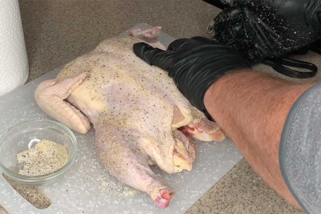 Adding a light rub to raw whole chicken
