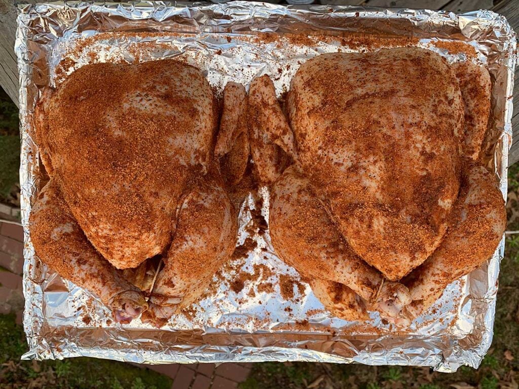 Two raw chickens with rub.