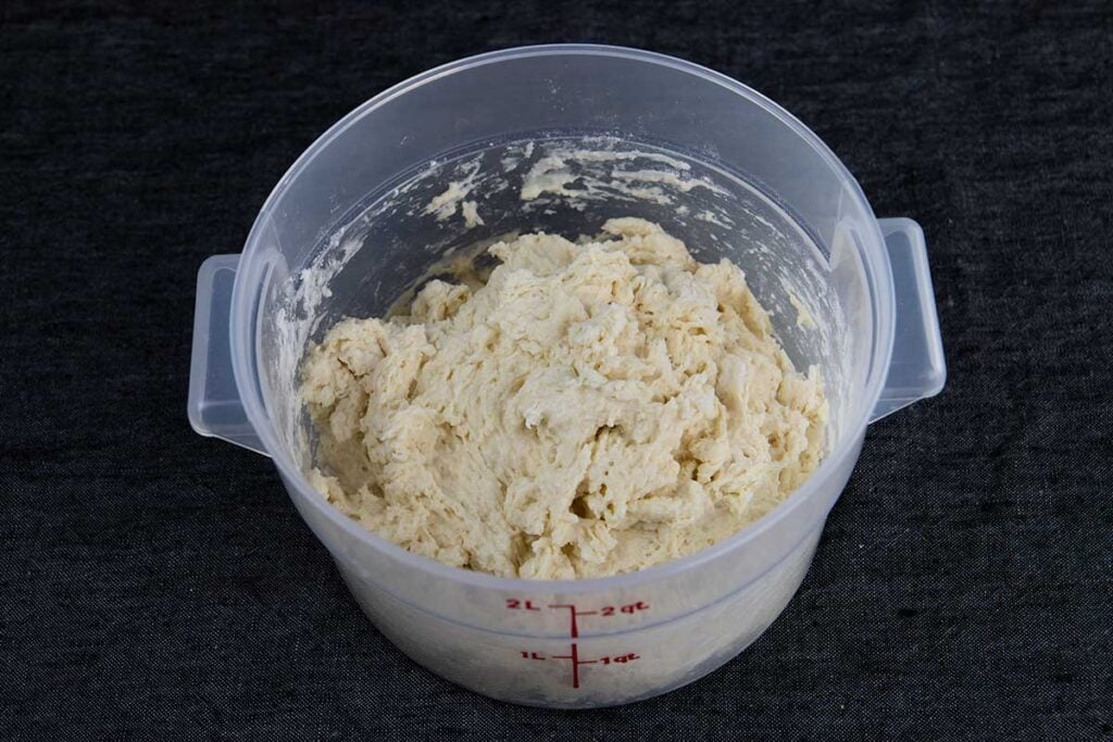 Sourdough dough in a plastic container.