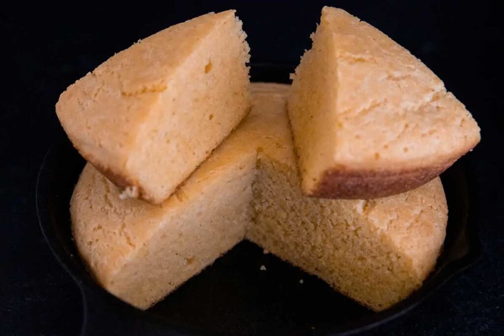 Sliced buttermilk cornbread in a cast iron skillet.