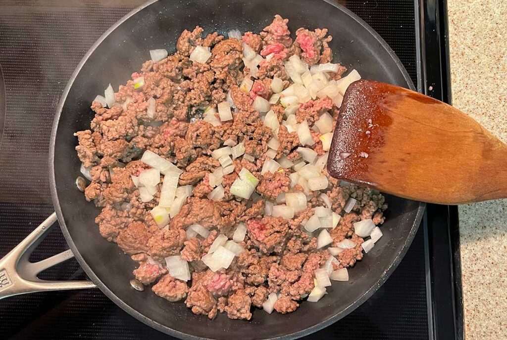 Ground beef and onion browning in a skillet