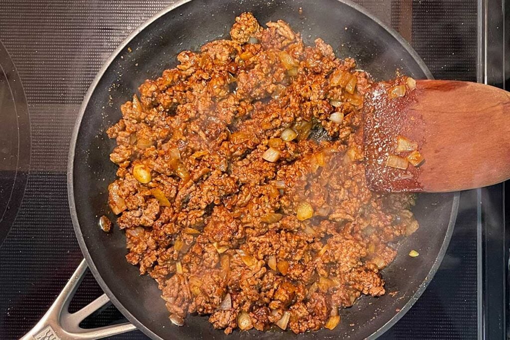 Browned beef, onions, and mexican spices in a skillet