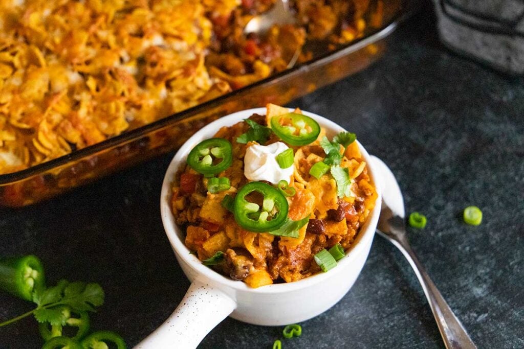 Frito pie casserole in a white bowl.