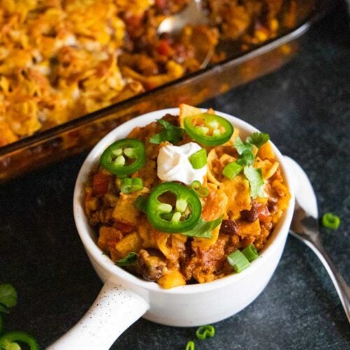 Frito pie casserole in a white bowl.