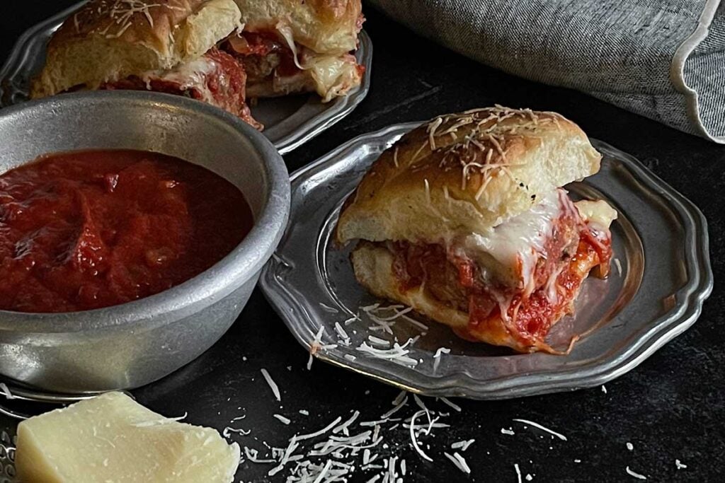 Meatball slider on a pewter plate.