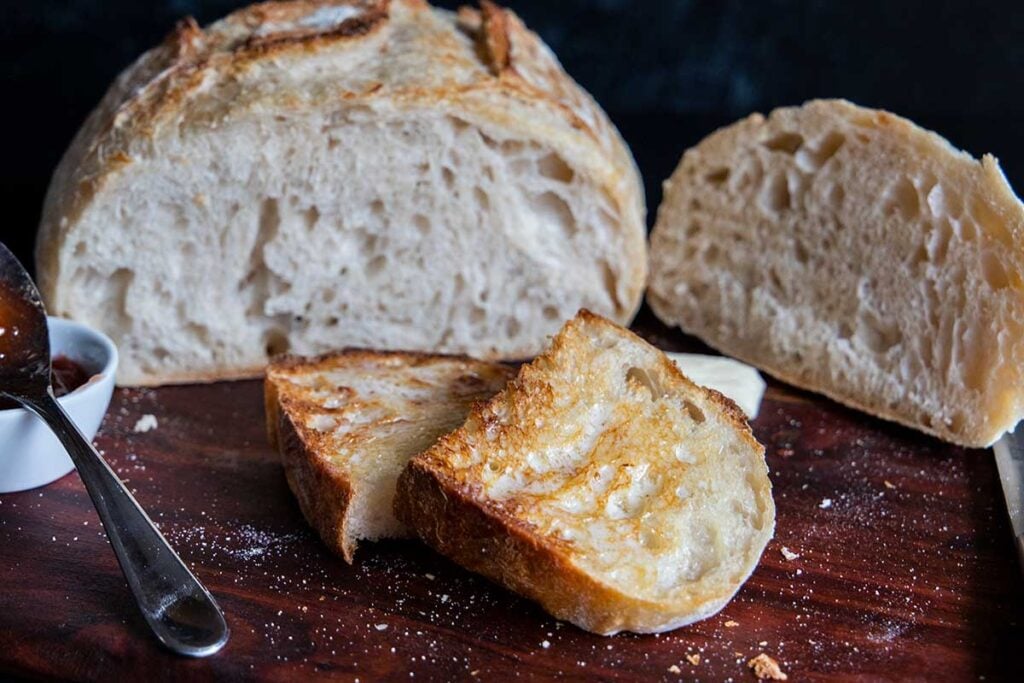 Sourdough bread sliced and toasted on a wooden board.