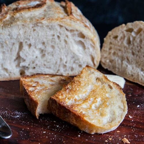 Sourdough bread sliced and toasted on a wooden board.