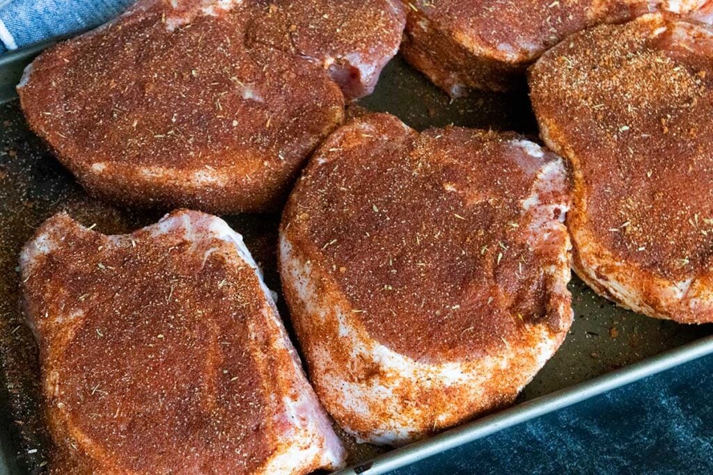 Double bone-in pork chops with rub applied.