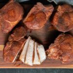 Double bone in pork chops sliced on a cutting board.