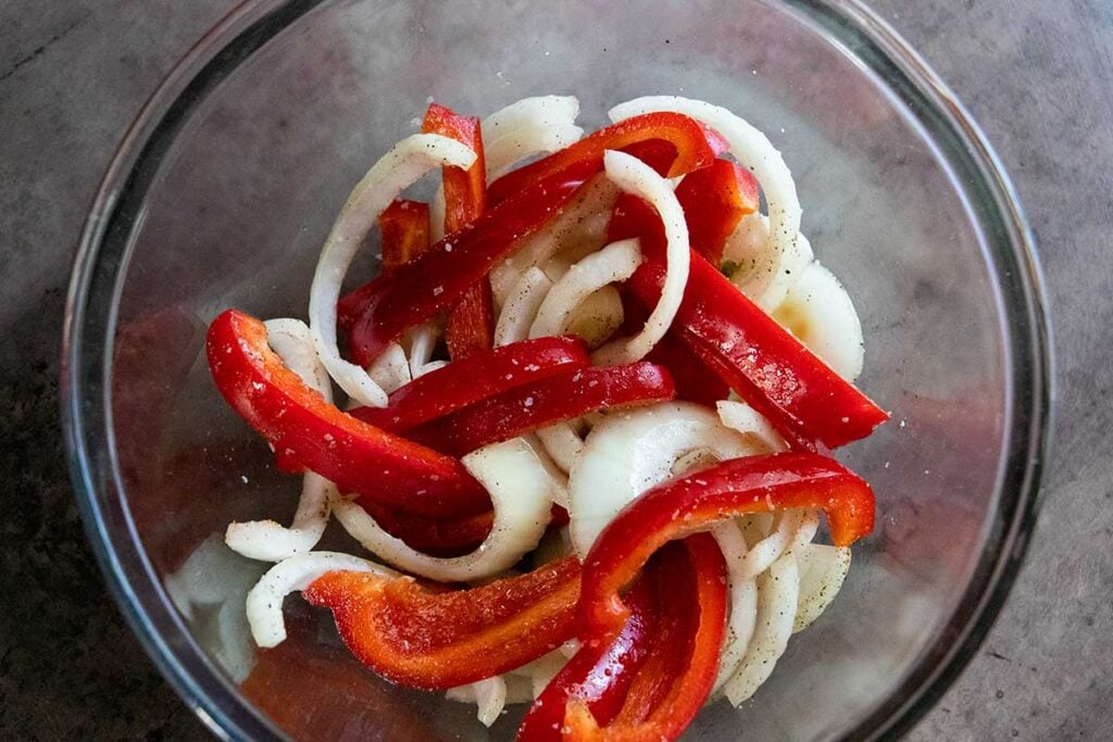 Onions and red peppers cut in a glass bowl