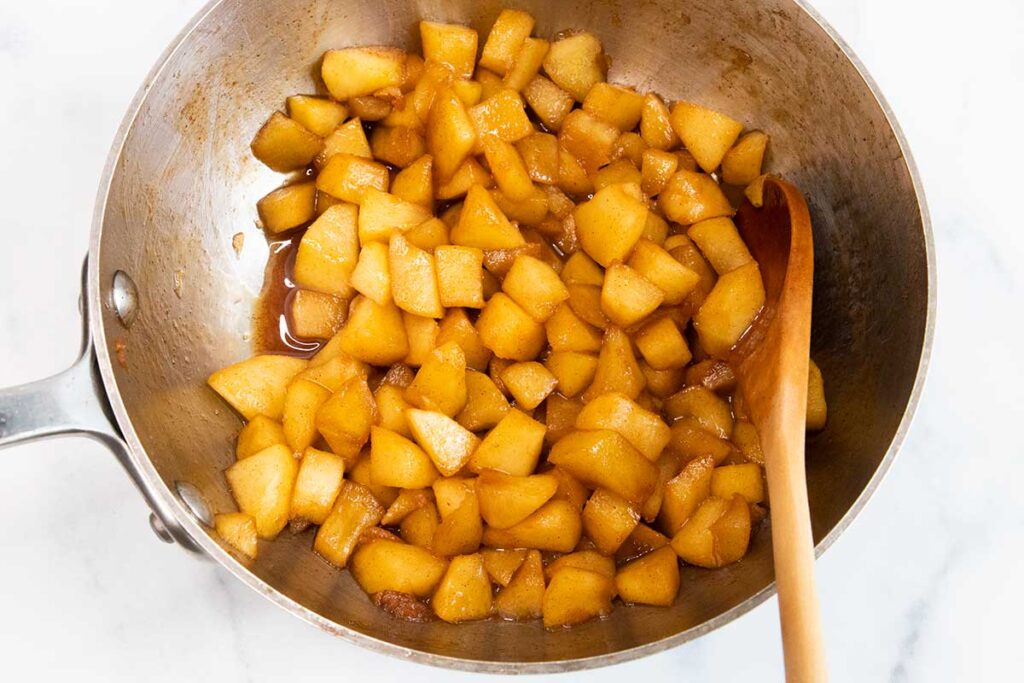 Chopped apples cooked in a saucepan.