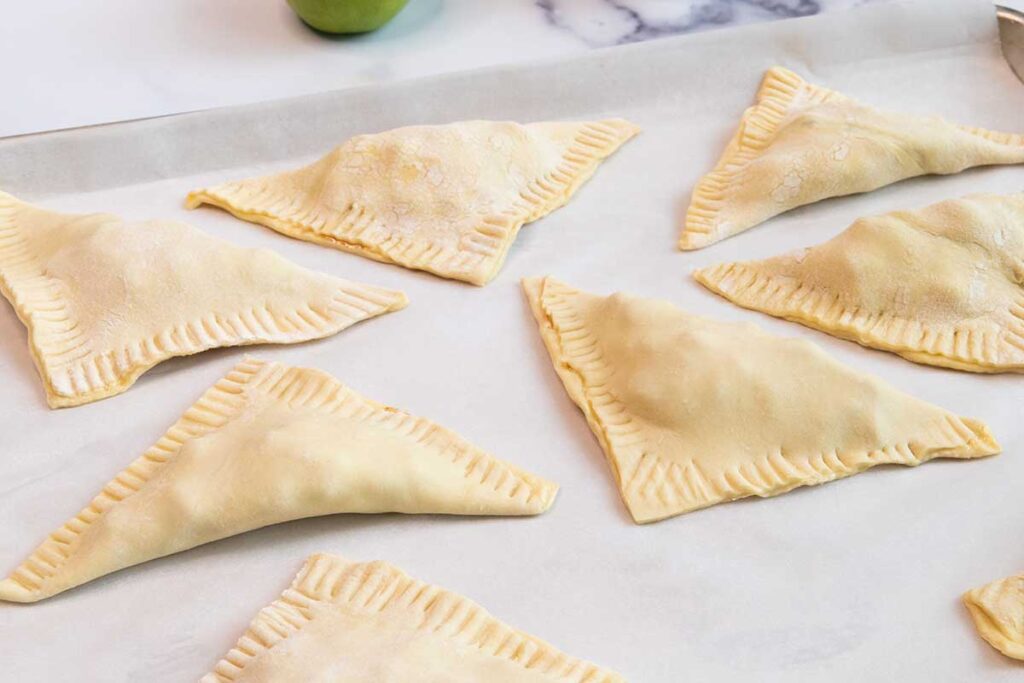 formed apple turnovers on a baking sheet