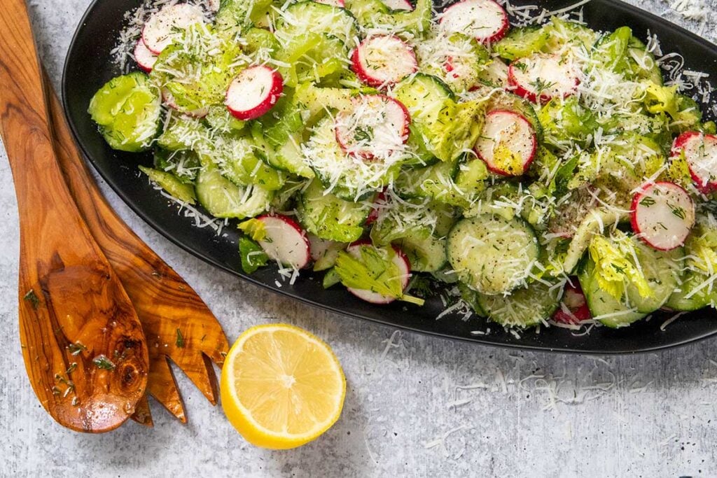 Cucumber radish salad on a black platter.