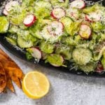 Cucumber radish salad on a black platter.