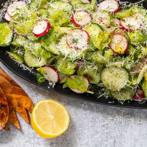 Cucumber radish salad on a black platter.