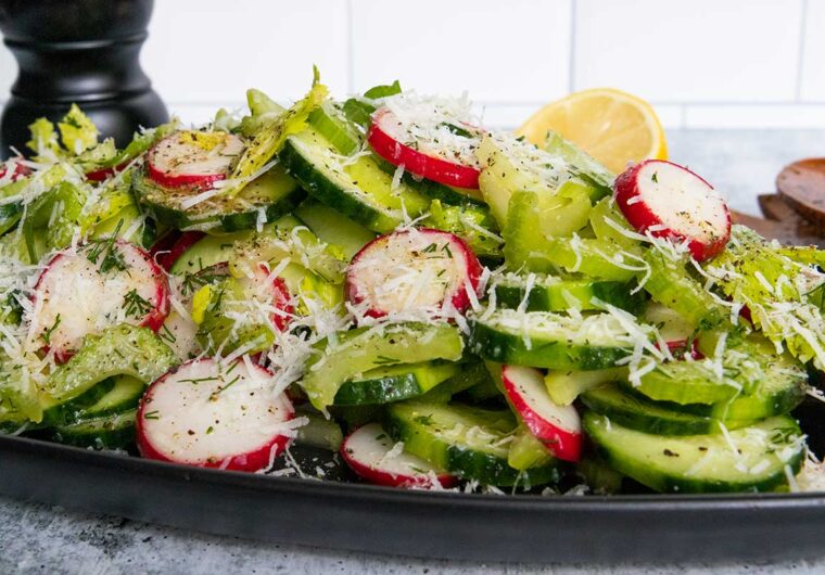 cucumber radish salad on a black platter