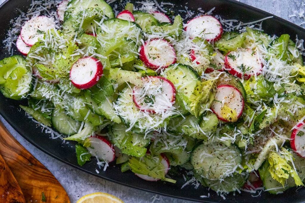 cucumber radish salad on a black platter