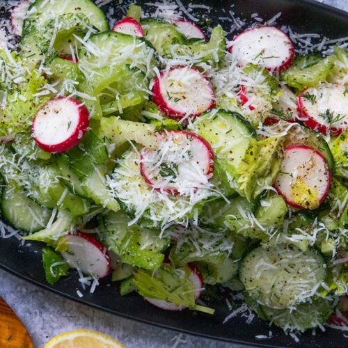 cucumber radish salad on a black platter