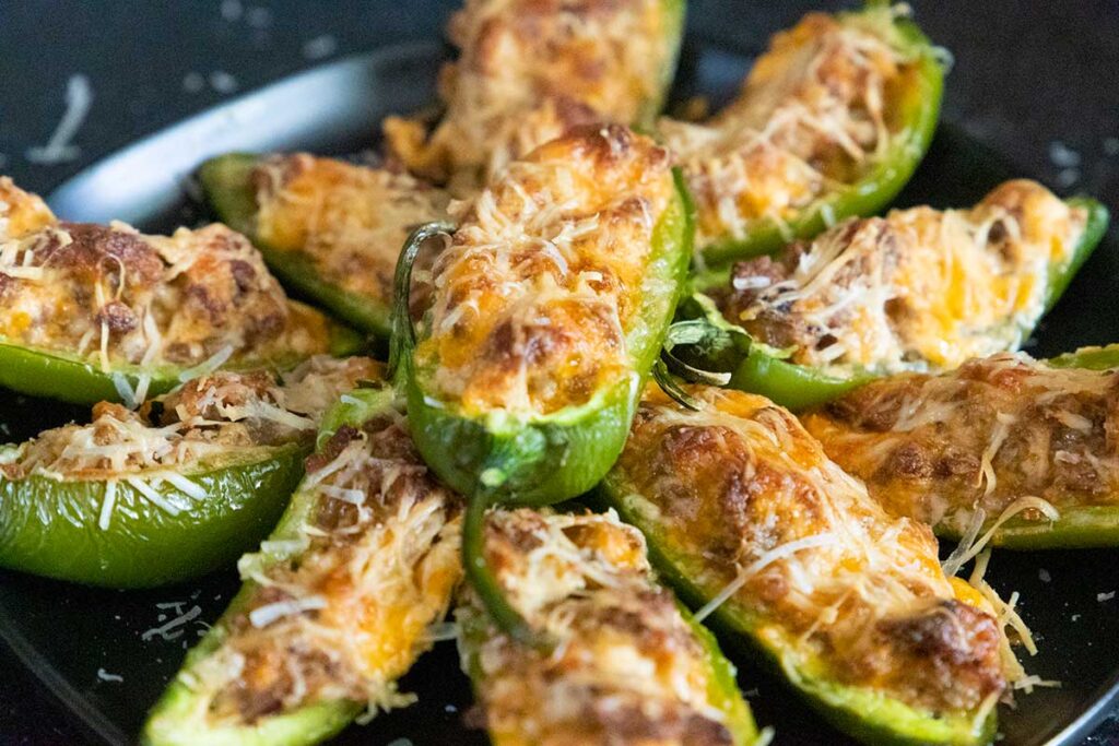 Jalapeno poppers on a black plate.