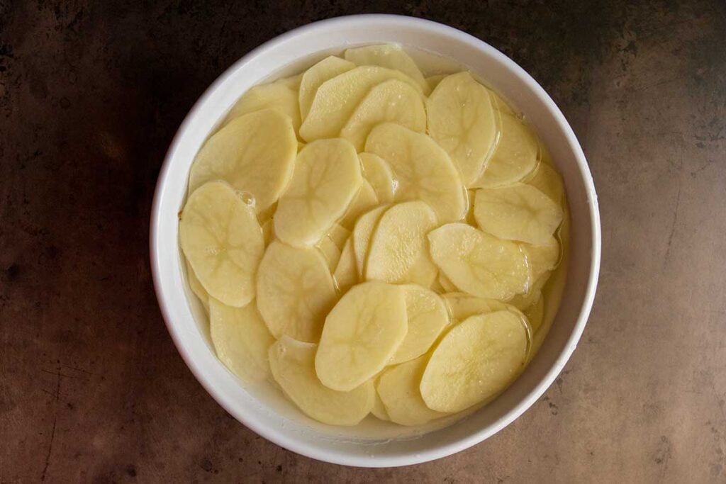 Sliced potatoes in water.
