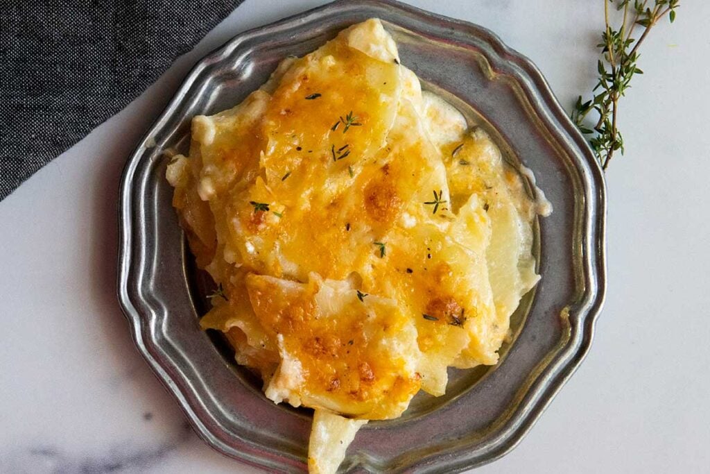 Potatoes Au Gratin with Gruyere cheese on a pewter platter.