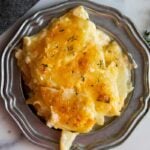 Potatoes Au Gratin with Gruyere cheese on a pewter platter.
