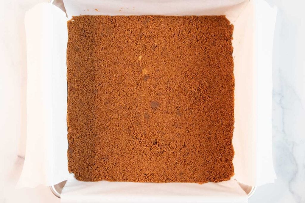 Gingersnap cookie crust in a baking pan.