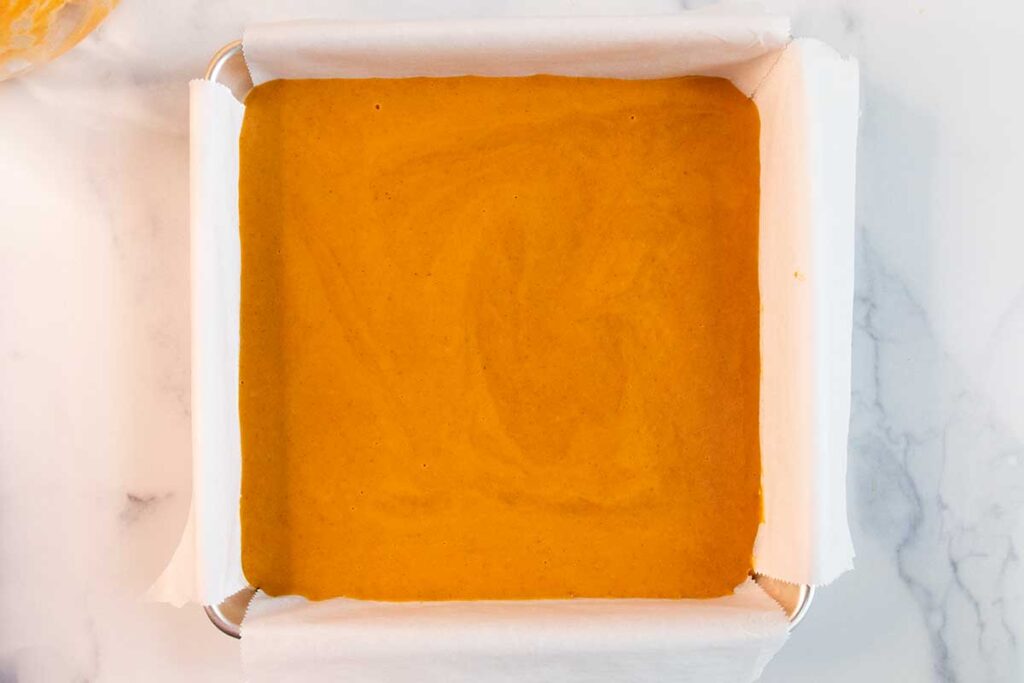 Pumpkin pie bar batter in a baking pan.