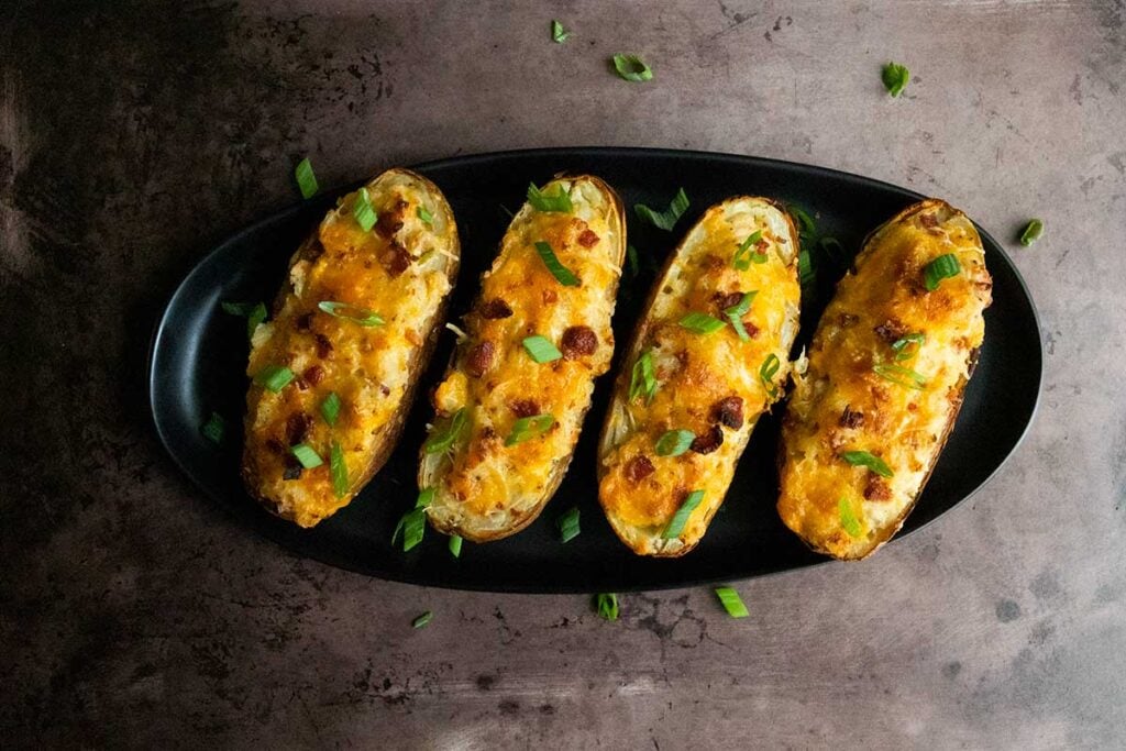 twice baked potatoes on a black serving dish