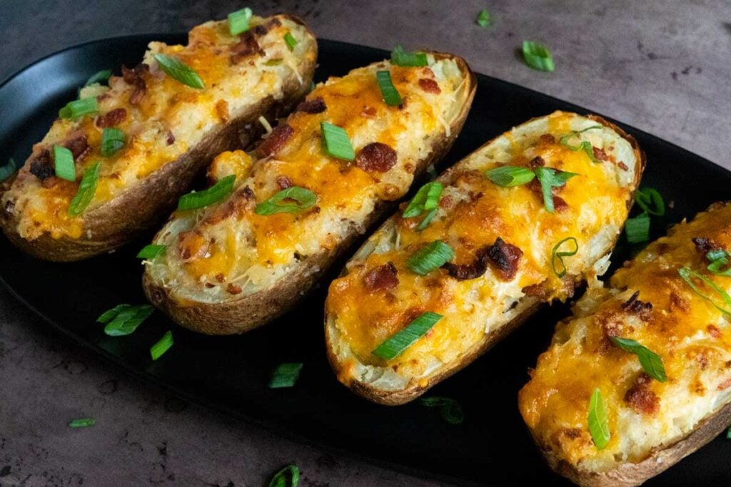 Twice baked potatoes on a black serving platter