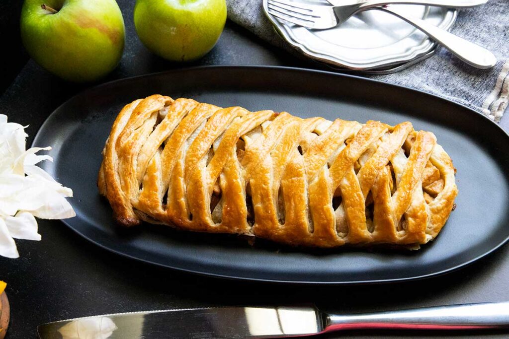 Apple strudel on black platter.