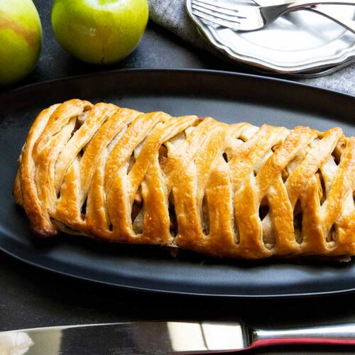 Apple strudel on black platter.