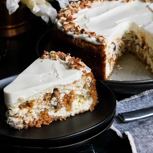 slice of carrot cake cheesecake on black plate