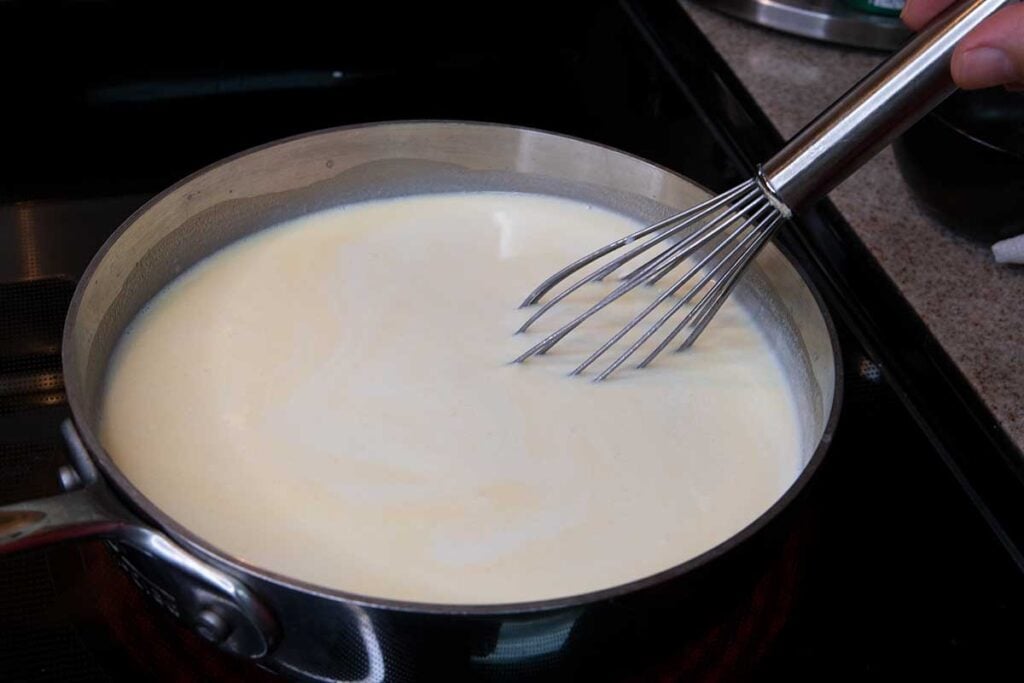 Preparing sauce for baked macaroni and cheese.