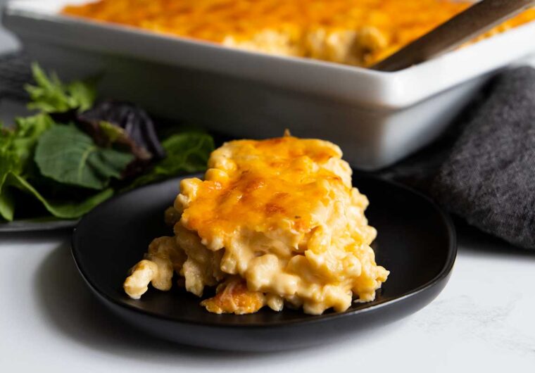 a serving of macaroni and cheese on a black plate