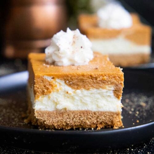 pumpkin cheesecake bars on a black plate