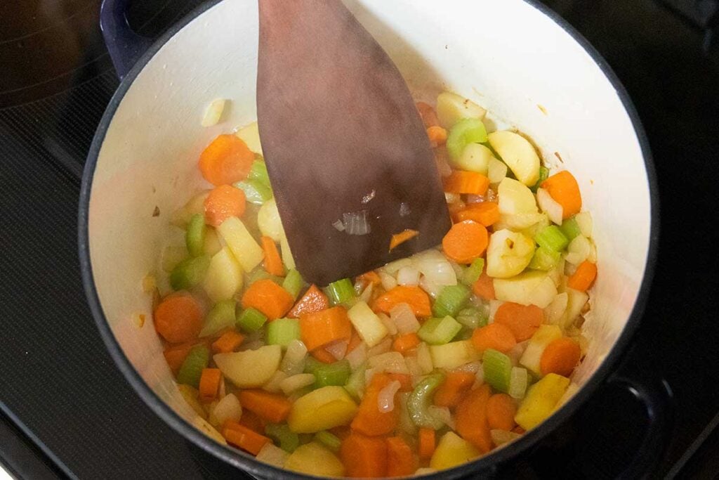 Vegetables cooking in a large pot.