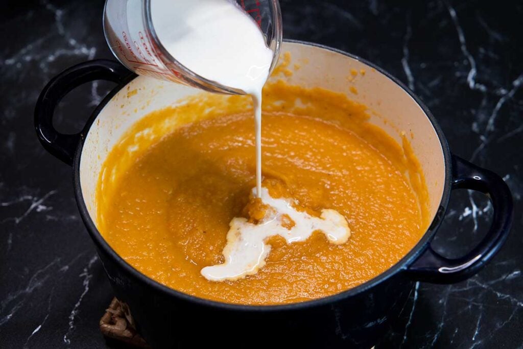 cream being added to the pureed soup