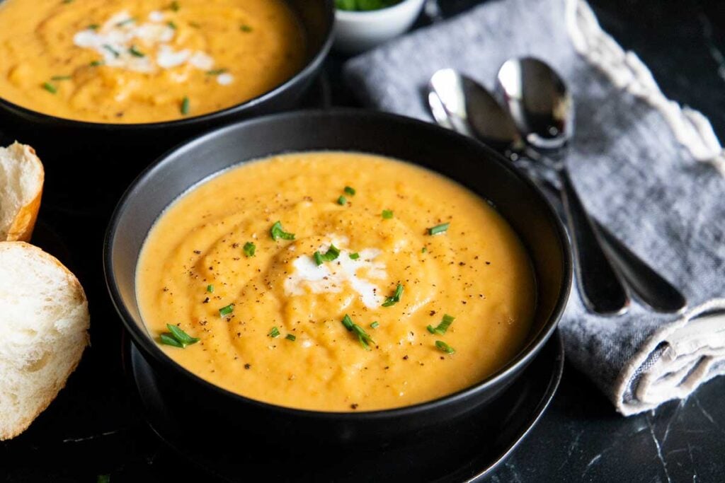 root vegetable soup in black bowls