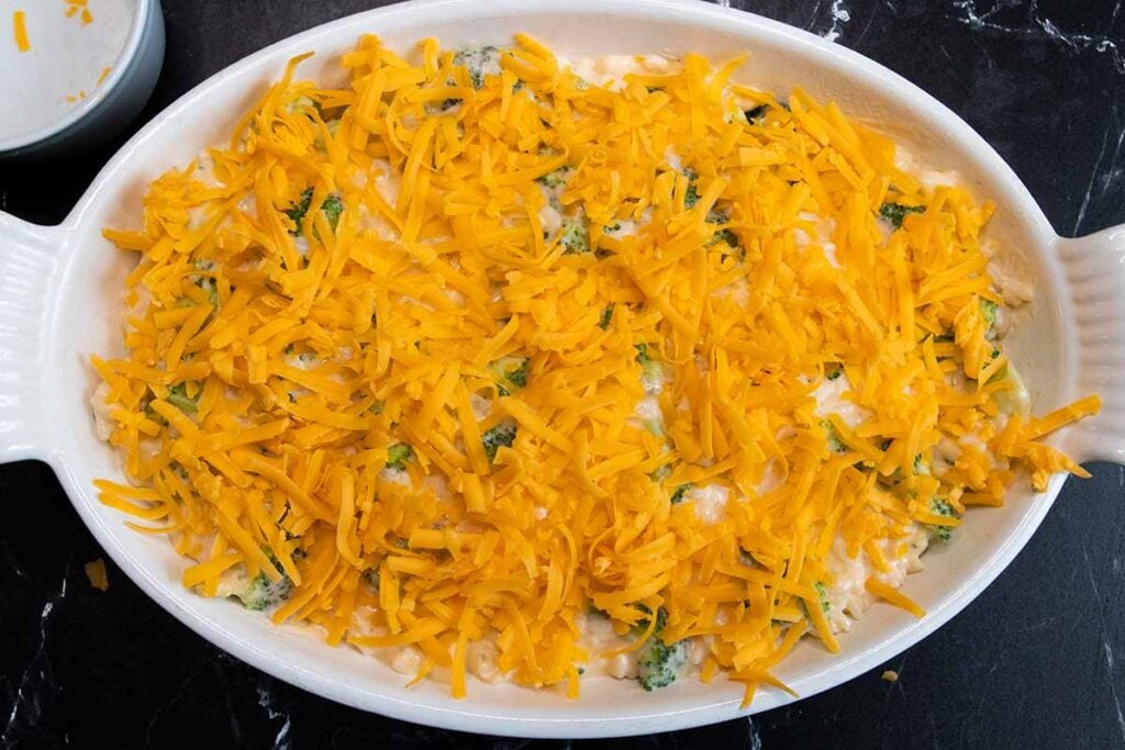 unbaked casserole topped with shredded cheddar cheese