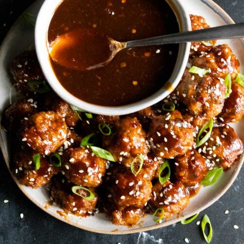 Asian inspired meatballs on a serving platter with sauce