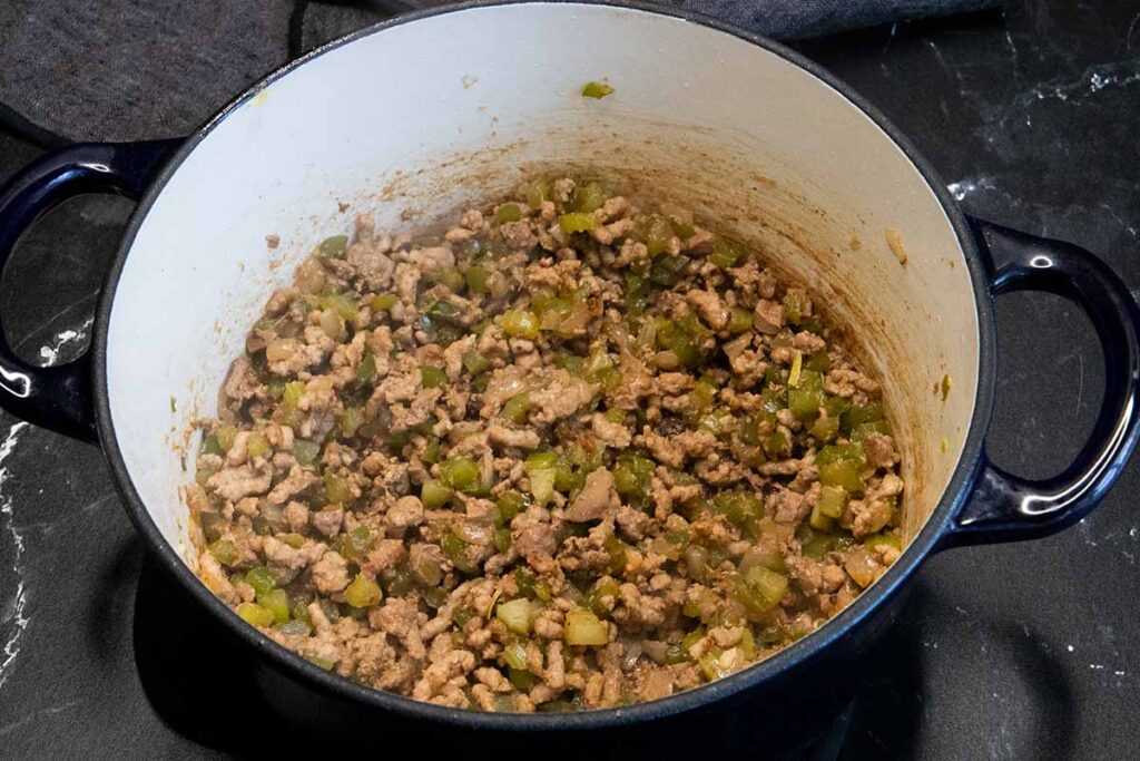 Meat mixture for cajun dirty rice cooked in a blue dutch oven