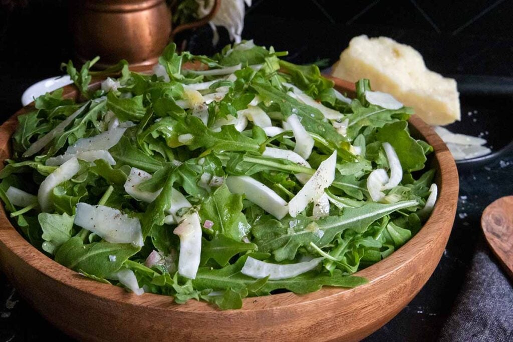 Arugula fennel salad in a wooden bowl.