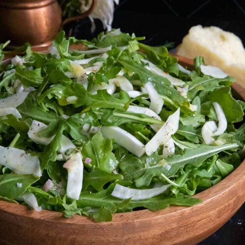 Arugula fennel salad in a wooden bowl.