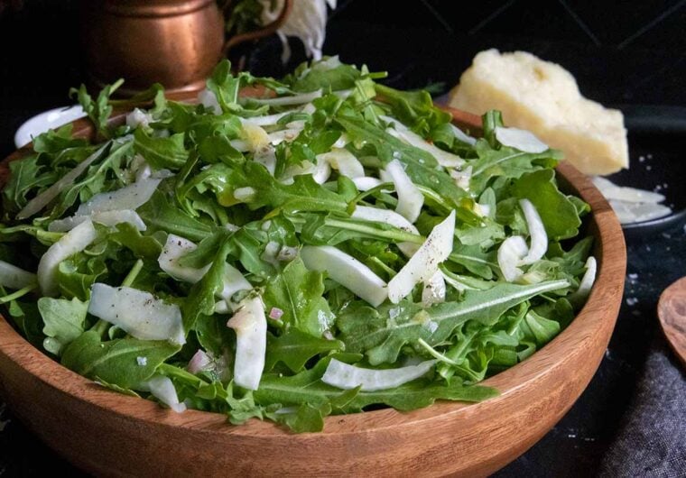 arugula fennel salad in a wooden bowl