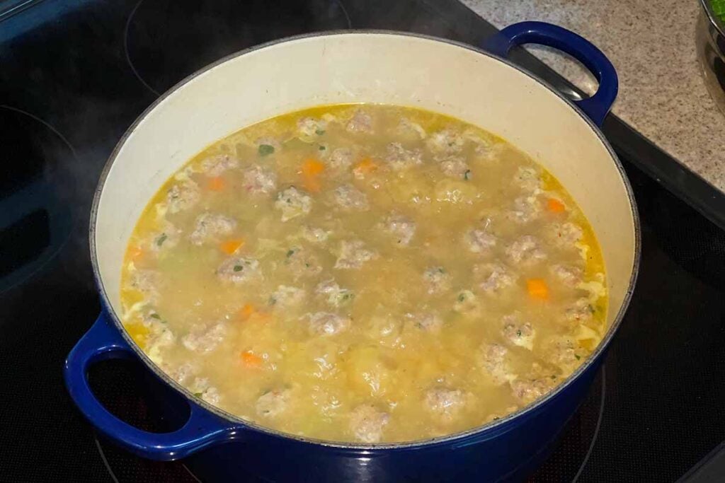 Soup in a large blue dutch oven on the stove.