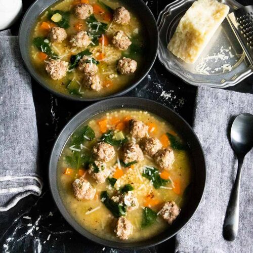 Italian wedding soup in black bowls.